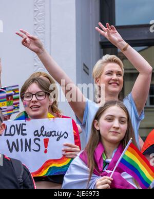 Schwerin, Deutschland. 25.. Juni 2022. Manuela Schwesig (SPD, r), Ministerpräsidentin von Mecklenburg-Vorpommern, feiert mit Teilnehmern am Christopher Street Day 16. unter dem Motto „Wissen schafft Vielfalt“. Farbenfroh kostümiert versammelt sich die meist jüngere Menge im Alten Garten. Die CSD soll die Menschen an die Rechte von Lesben, Schwulen, Bisexuellen, Transgender, Intersex und queeren Menschen erinnern. Quelle: Jens Büttner/dpa/Alamy Live News Stockfoto