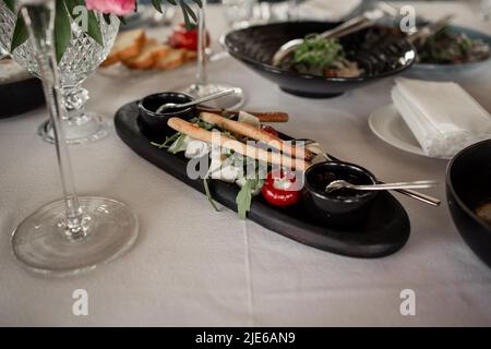 Eine Vorspeise mit Grissini-Sticks und Tomaten auf dem Tisch im Restaurant Stockfoto