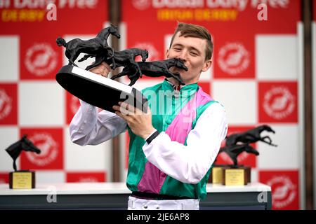 Jockey Colin Keane feiert den Tropy, nachdem er am zweiten Tag des Dubai Duty Free Irish Derby Festivals auf der Curragh Racecourse in der Grafschaft Kildare, Irland, das Dubai Duty Free Irish Derby mit dem Pferd Westover gewonnen hat. Bilddatum: Samstag, 25. Juni 2022. Stockfoto