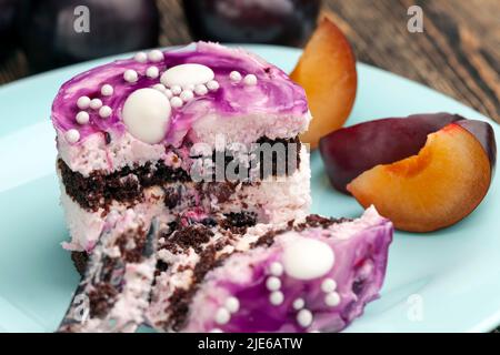Köstlicher Schokoladen-Milchkuchen aus mehreren süßen Lagen, süßer Lila-Schichtenkuchen mit dem Geschmack von Heidelbeeren Stockfoto