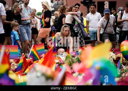 Oslo, Norwegen. 25.. Juni 2022. Am Samstag, den 25. Juni 2022, reagieren Menschen, die Blumen am Drehort im Zentrum von Oslo, Norwegen, legen. Ein Schütze eröffnete am frühen Samstag das Feuer in Oslos Nachtleben, tötete zwei Menschen und hinterließ mehr als 20 Verletzte in dem, was der norwegische Sicherheitsdienst während des jährlichen Pride-Festivals der Hauptstadt als „islamistischen Terrorakt“ bezeichnete. Foto: Björn Larsson Rosvall / TT / kod 9200 Quelle: TT News Agency/Alamy Live News Stockfoto