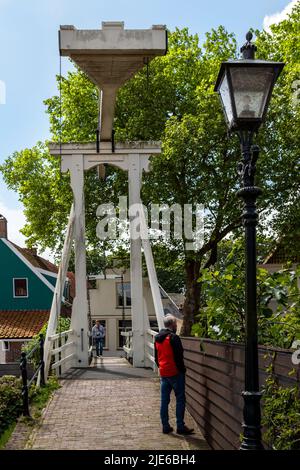 Sightseeing-Touristen an der Kwakelbrug, eine Bascule oder Wippe Brücke und Wahrzeichen in der Altstadt von Edam, Nordholland, Niederlande. Stockfoto