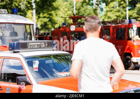 Hannover, Deutschland. 25.. Juni 2022. Auf dem Trammplatz in der Innenstadt Hannovers stehen zum Tag der deutschen Feuerwehrleute 29. verschiedene historische Feuerwehrfahrzeuge, die ein Besucher anschaut. Kredit: Michael Matthey/dpa/Alamy Live Nachrichten Stockfoto