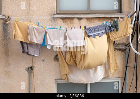 Bettwäsche und Kleidung werden an einem Seil auf der Straße in Israel getrocknet Stockfoto