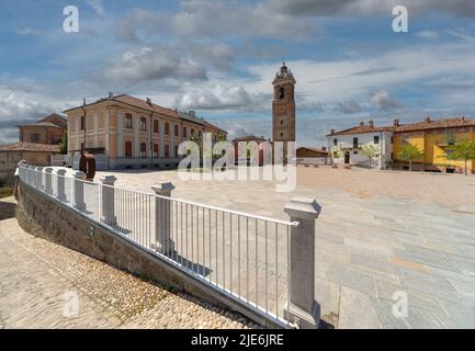 La Morra, Langhe, Italien - 02. Mai 2022: Piazza Castello mit dem Glockenturm und dem nach Maria und Luigi Oberto benannten Schulgebäude. Im Vorhinein Stockfoto