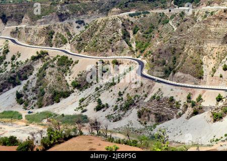 Eine kurvenreiche Straße, die durch den Rand der Berge führt und eine atemberaubende Landschaft bietet Stockfoto