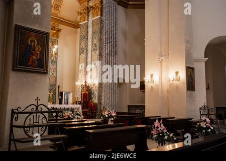 Eine Holzbänke in einem katholischen Kircheninneren Stockfoto