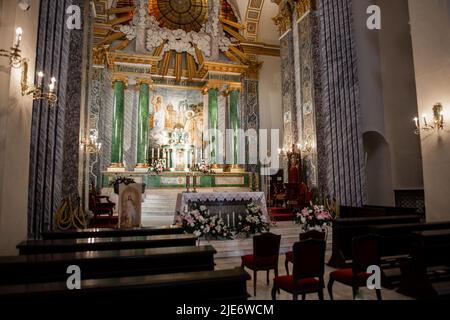 Eine Holzbänke in einem katholischen Kircheninneren Stockfoto