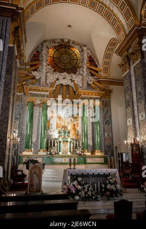 Eine Holzbänke in einem katholischen Kircheninneren Stockfoto