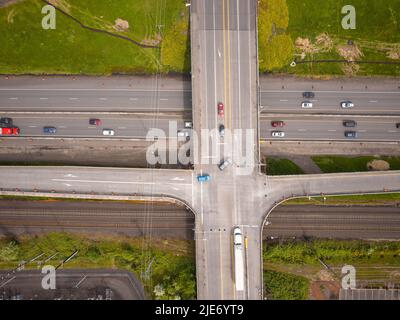 Schießen von einer Drohne. Autobahn, Kreuzung. Grüne Rasenflächen auf beiden Seiten. Reisen, Tourismus, entwickelte Infrastruktur. Bau, Planung, Ökologie, Stockfoto