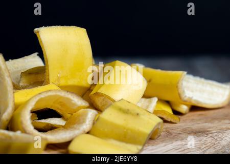 Die gelbe Schale, die nach den Bananen auf dem Brett zurückgelassen wurde, die leere Schale der Bananen, nachdem sie gereinigt wurden, das ist Müll Stockfoto