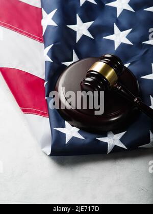 Holzgavel des Richters auf dem Hintergrund der amerikanischen Flagge. Gericht, Verbrechen, Bestrafung, Rechtsstaatlichkeit, Verfassung Nahaufnahme. Es sind keine Personen drin Stockfoto