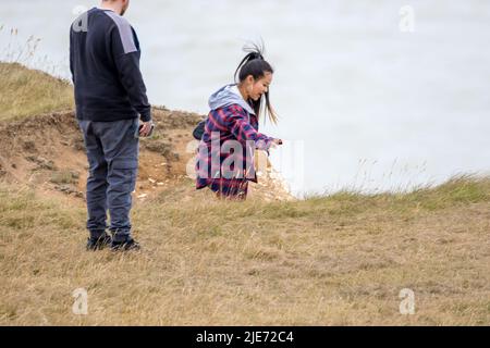 Beachy Head, Eastbourne, Großbritannien. 25.. Juni 2022. Touristen und Besucher dieser beliebten Südküsten-Klippe, die über 500 Meter am höchsten Punkt liegt, sind sich nicht bewusst, welche großen Risiken sie bei der Pose für Fotos eingehen. Die jüngsten Berichte über weitere Risse in der fragilen Kreide und regelmäßige Felsstürze stellen weiterhin ein großes Problem dar. Kredit: Newspics UK South/Alamy Live Nachrichten Stockfoto