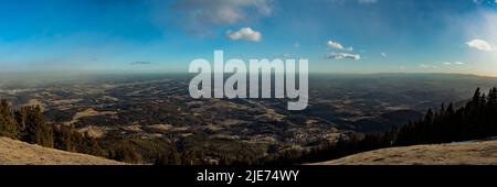 Luftpanorama der alpinen Hügel in der Südsteiermark vom Gipfel des Schöckl bei Graz mit blauer Himmelswolke am sonnigen Wintertag, Sankt Radegund, Au Stockfoto