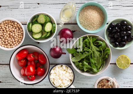 Eine Reihe von Produkten für vegetarische Gerichte in mehreren Schüsseln, frisches Gemüse, Kichererbsen, Olivenöl Stockfoto