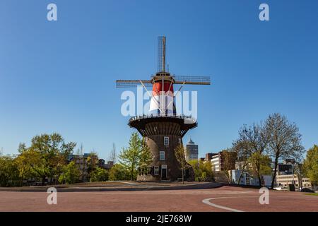 Historisches holländisches Windmil Molen de Valk mit holländischer Flagge in Leiden, Niederlande an einem Sommertag mit einem strahlend blauen Himmel Stockfoto