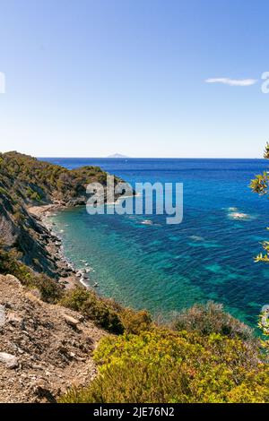 Blick über den Ogiera Strand, ein kleiner freier, wilder Strand mit dunklem Sand, Felsen und Steinen in der Nähe von Pomonte, perfekt zum Schnorcheln und Tiefseetauchen Stockfoto