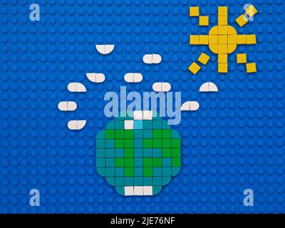 Tambow, Russische Föderation - 14. Juni 2022 der Planet Erde, die Sonne und Wolken am Himmel. Die Szene besteht aus Lego-Punkten. Stockfoto