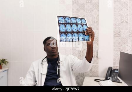 Der Arzt in der Arztpraxis untersucht die Bilder der Magnetresonanztherapie Stockfoto