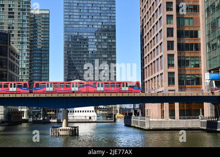 London, England - Juni 2022: Fahrerloser Personenzug der Docklands Light Railway auf einer Brücke über einen der Docks in Canary Wharf Stockfoto