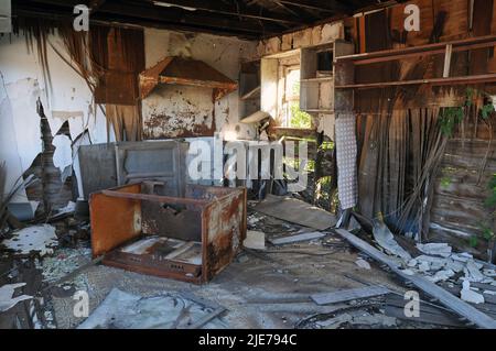 Innenansicht einer verlassenen Holzhütte, aufgenommen durch ein offenes Fenster, in der kleinen Route 66-Stadt Texola in der Nähe der Texas State Line. Stockfoto