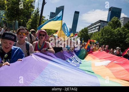 Warschau, Polen. 25.. Juni 2022. Während der Warschauer Pride halten Menschen Regenbogen- und ukrainische Fahnen fest. Die Organisation Kyiv Pride nahm an der parade zur Gleichstellung in Warschau Teil, um ihr 10.-jähriges Bestehen und die Rechte der ukrainischen LGBTQ-Bevölkerung zu feiern. Warschau und Kyiv Pride marschieren in diesem Jahr wegen der russischen Invasion in der Ukraine in der polnischen Hauptstadt zusammen. Die Warsaw Pride, auch bekannt als Equality Parade, brachte Tausende von Menschen auf die Straßen von Warschau, um die Ideen von Freiheit, Gleichheit und Toleranz zu verbreiten. Kredit: SOPA Images Limited/Alamy Live Nachrichten Stockfoto