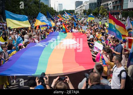 Warschau, Polen. 25.. Juni 2022. Während der Warschauer Pride halten Menschen Regenbogen- und ukrainische Fahnen fest. Die Organisation Kyiv Pride nahm an der parade zur Gleichstellung in Warschau Teil, um ihr 10.-jähriges Bestehen und die Rechte der ukrainischen LGBTQ-Bevölkerung zu feiern. Warschau und Kyiv Pride marschieren in diesem Jahr wegen der russischen Invasion in der Ukraine in der polnischen Hauptstadt zusammen. Die Warsaw Pride, auch bekannt als Equality Parade, brachte Tausende von Menschen auf die Straßen von Warschau, um die Ideen von Freiheit, Gleichheit und Toleranz zu verbreiten. Kredit: SOPA Images Limited/Alamy Live Nachrichten Stockfoto