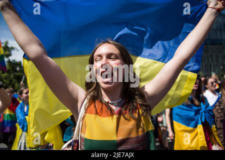 Warschau, Polen. 25.. Juni 2022. Eine Frau ruft Slogans, während sie während des Warschauer Pride eine ukrainische Flagge hält. Die Organisation Kyiv Pride nahm an der parade zur Gleichstellung in Warschau Teil, um ihr 10.-jähriges Bestehen und die Rechte der ukrainischen LGBTQ-Bevölkerung zu feiern. Warschau und Kyiv Pride marschieren in diesem Jahr wegen der russischen Invasion in der Ukraine in der polnischen Hauptstadt zusammen. Die Warsaw Pride, auch bekannt als Equality Parade, brachte Tausende von Menschen auf die Straßen von Warschau, um die Ideen von Freiheit, Gleichheit und Toleranz zu verbreiten. Kredit: SOPA Images Limited/Alamy Live Nachrichten Stockfoto