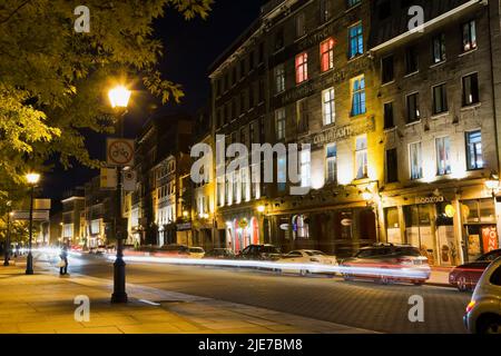 Die Straße de la Commune ist nachts beleuchtet, mit vorbeiziehenden Scheinwerferstreifen, Old Montreal, Quebec, Kanada. Stockfoto