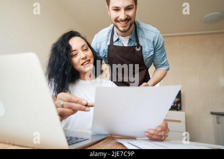 Freudige Frau, die dem glücklichen Mann Dokumente zeigt Stockfoto