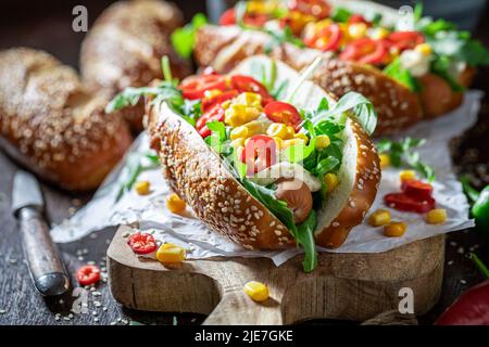 Heiße und hausgemachte Hot Dogs aus würziger Sauce und Schweinewurst. Würzige Hot Dogs aus Gemüse und Chilisauce. Stockfoto