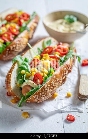 Ungesunde und leckere Hot Dogs mit Rucola, Chili und Mais. Würzige Hot Dogs aus Gemüse und Chilisauce. Stockfoto