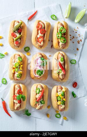 Heiße und hausgemachte Mini-Hot Dogs mit Wurst und Sauce. Mini Hot Dogs mit würziger Wurst und Senf. Stockfoto