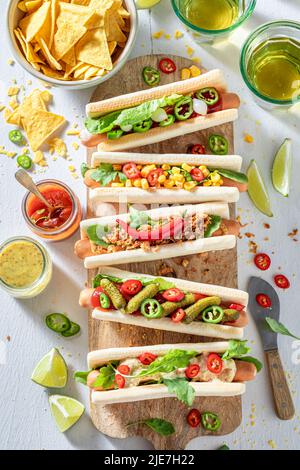 Heiße und hausgemachte Hot Dogs mit Senf und Ketchup. Hot Dogs mit würzigen Addons und serviert mit Limonade. Stockfoto