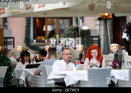 Warschau, Polen. 25.. Juni 2022. Eine Frau trinkt während des sommerlichen Abendessens im Restaurant in der Warschauer Altstadt ein Bier. Tägliches Leben am Sommerabend in der Warschauer Altstadt nach einem heißen Samstag. (Foto von Volha Shukaila/SOPA Images/Sipa USA) Quelle: SIPA USA/Alamy Live News Stockfoto