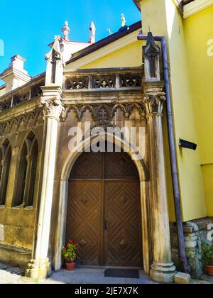 Zweiblättrige Holztür unter einem halbrunden Steinbogen Stockfoto