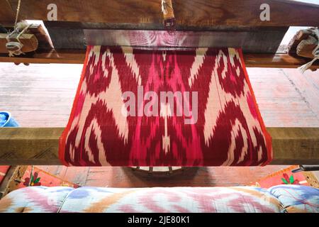 Seiden-Ikat Traditionelles, ikonisches Design auf einem Handwebstuhl. In der Yodgorlik Seidenfabrik in Margilan, Fergana-Tal, Usbekistan. Stockfoto