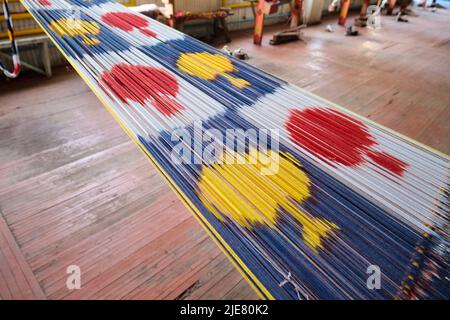 Seiden-Ikat Traditionelles, ikonisches Design auf einem Handwebstuhl. In der Yodgorlik Seidenfabrik in Margilan, Fergana-Tal, Usbekistan. Stockfoto
