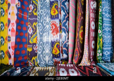 Beispiele für die vielen traditionellen ikat-Stoffe, textile Designs in Seide, Tücher, Wraps. In der Yodgorlik Seidenfabrik in Margilan, Fergana Valley, Uzbe Stockfoto