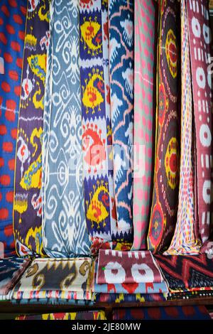 Beispiele für die vielen traditionellen ikat-Stoffe, textile Designs in Seide, Tücher, Wraps. In der Yodgorlik Seidenfabrik in Margilan, Fergana Valley, Uzbe Stockfoto