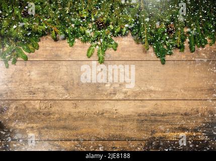Weihnachtsrahmen mit Schnee und Zapfen. Weihnachtshintergrund mit Tannenbaum, Süßigkeiten und Kugeln. Weihnachten rustikalen Hintergrund mit Weihnachtsbaum Kleie Stockfoto