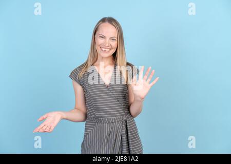 Überraschung und Schock. Weibliche Halbportrait isoliert im Blue Studio. Nette kaukasische emotional überrascht Frau breitet ihre Arme zu Seiten. Menschliche Emotionen, Gesichtsausdruck Konzept. Trendige Farben. Vorne Stockfoto