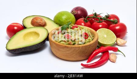 Holzschüssel mit Guacamole Dip-Sauce und Zutaten auf weißem Hintergrund isoliert Stockfoto