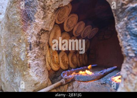 Reihen von nicht-Brot, auf einer tandir Innenfläche geklebt, Backen. Diese Operation ist eine typische kleine, lokale, hinter einem Haus versteckt, eingerichtet. In Namangan, F Stockfoto