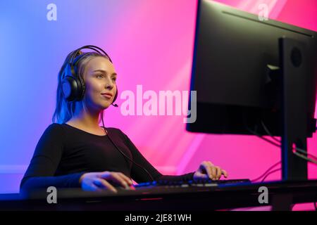 Happy Gamer Girl mit Headset spielt Online-Videospiel auf dem PC Stockfoto