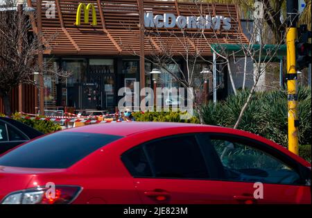 Autoverkehr und Frau mit Gesichtsschutzmaske, die während des Covid 19, 2020 vor einem geschlossenen McDonald's-Geschäft in Sofia, Bulgarien, stand Stockfoto