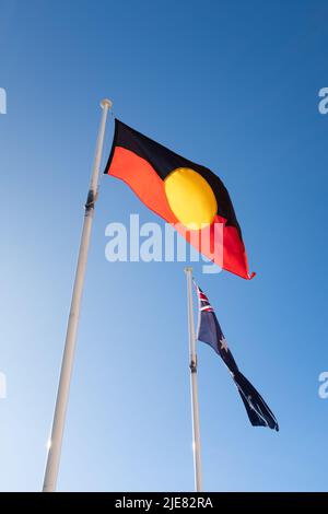 Eine indigene Ureinwohner-Flagge der Ureinwohner vor einer australischen Flagge Stockfoto