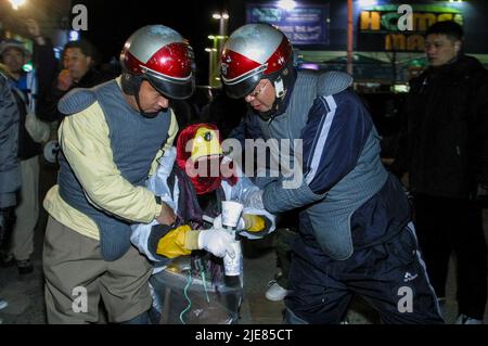 24. Nov 2003-Buan, Südkorea-Riot Polizisten verhaften Großmutter auf der Straße in Buan-Guns Innenstadt, Südkorea. Das Ministerium für Handel, Industrie und Energie wählt eine kleine Insel vor Buan, einem Landkreis in der Provinz Nord-Jeolla, als Standort für eine nukleare Abfallentsorgungsanlage aus. Das Projekt brach jedoch aufgrund des starken Widerstands der Einwohner von Buan im Jahr 2004 zusammen. Die Regierung beschloss im Mai 2004, Anträge von regionalen Behörden zu erhalten, die die Fazilität als Gegenleistung für finanzielle Vorteile akzeptieren möchten. Stockfoto