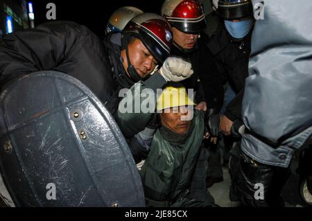 24. Nov 2003-Buan, Südkorea-Polizei von Riot verhaften älteren Mann auf der Straße in der Innenstadt von Buan-Gun, Südkorea. Das Ministerium für Handel, Industrie und Energie wählt eine kleine Insel vor Buan, einem Landkreis in der Provinz Nord-Jeolla, als Standort für eine nukleare Abfallentsorgungsanlage aus. Das Projekt brach jedoch aufgrund des starken Widerstands der Einwohner von Buan im Jahr 2004 zusammen. Die Regierung beschloss im Mai 2004, Anträge von regionalen Behörden zu erhalten, die die Fazilität als Gegenleistung für finanzielle Vorteile akzeptieren möchten. Stockfoto