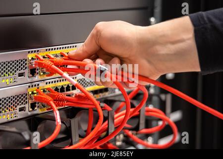 Nahaufnahme des männlichen Technikers, der Kabel in San einsteckt Stockfoto